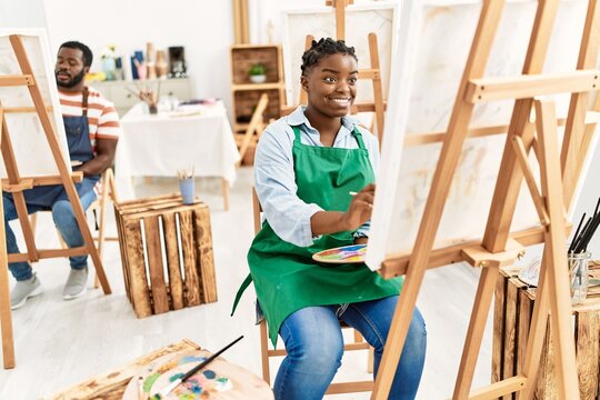 African american painter couple smiling happy painting at art studio.