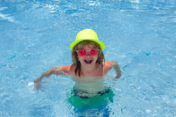 Fototapeta na wymiar Funny kids face. Child splashing in swimming pool. Swim water sport activity on summer vacation with child.