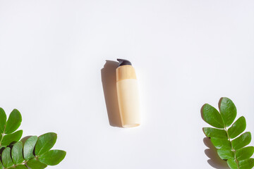Cosmetic bottles with green leaf on white background