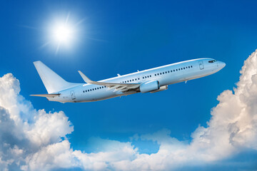 Fototapeta na wymiar White passenger airliner takes off in the blue sky