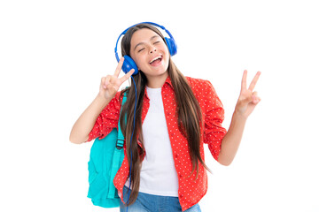School leisure. Amazed child singing. School girl in headphones on isolated studio background. School and music concept.