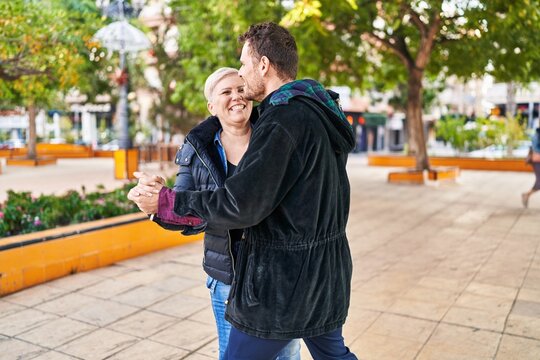 Mother and son smiling confident dancing at park