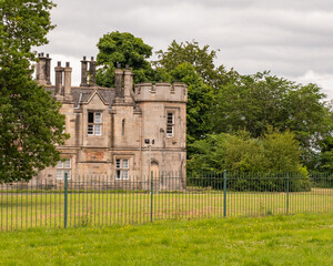 Fototapeta premium Cramond, Scotland, UK – June 21 2022. A section of a large and unidentifiable stone house located in North East Scotland on a dull and overcast day