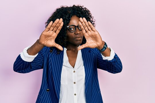 Young african american woman wearing business clothes and glasses doing frame using hands palms and fingers, camera perspective