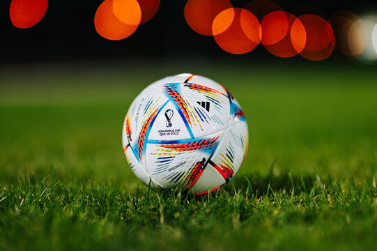 QATAR, DOHA, 18 JULY, 2022: Official Adidas Fifa World Cup Football Ball Al Rihla. World Championship in Qatar 2022. Soccer Match Ball on green grass in night at Stadium. FIFA 22, black edit space.