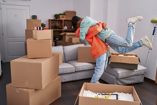 Two man couple hugging each other standing at new home - Powered by Adobe