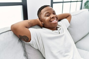 Young african man relaxing sitting on the sofa at home