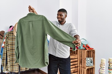 Young african american man smiling confident choosing clothes at clothing store