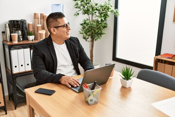Naklejka premium Young latin businessman smiling happy working using laptop at the office.