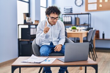 Hispanic man doing video call waving to laptop smiling with an idea or question pointing finger...