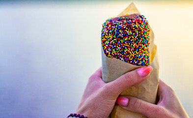 Woman holds in hand Trdlo or Trdelnik, Traditional tasty baked Czech Republic. street food