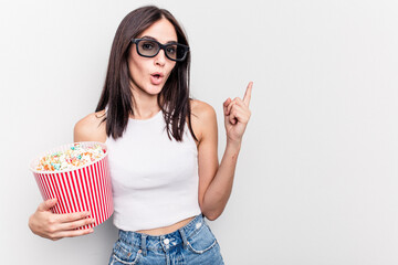 Young caucasian woman eating popcorn isolated on white background pointing to the side