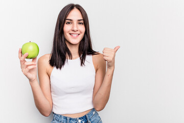 Young caucasian woman holding an apple isolated on white background smiling and raising thumb up