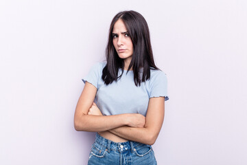Young caucasian woman isolated on pink background suspicious, uncertain, examining you.