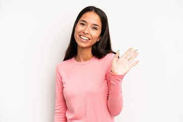 hispanic pretty woman smiling happily and cheerfully, waving hand, welcoming and greeting you, or...