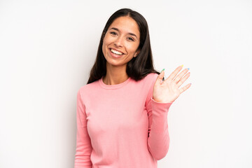 hispanic pretty woman smiling happily and cheerfully, waving hand, welcoming and greeting you, or saying goodbye © kues1