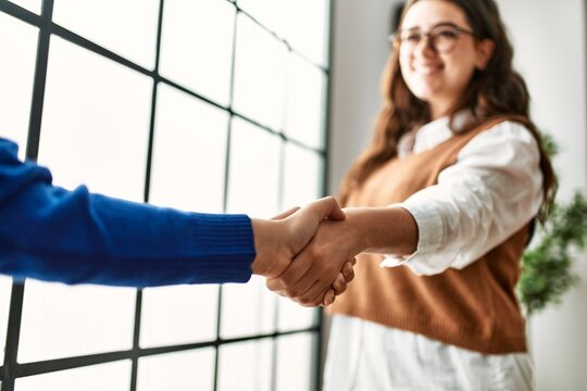 Two business workers woman shaking hands at the office.
