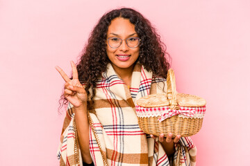 Young hispanic woman doing a picnic isolated on beige background showing number two with fingers.