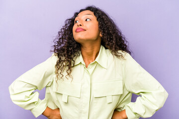 Young hispanic woman isolated on purple background dreaming of achieving goals and purposes