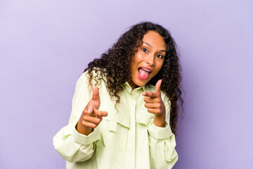 Young hispanic woman isolated on purple background cheerful smiles pointing to front.
