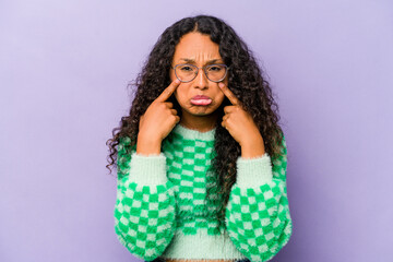 Young hispanic woman isolated on purple background crying, unhappy with something, agony and confusion concept.