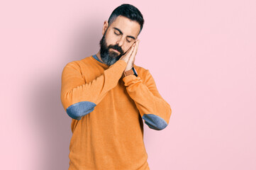 Hispanic man with beard wearing casual winter sweater sleeping tired dreaming and posing with hands together while smiling with closed eyes.