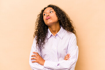 Obraz premium Young hispanic woman isolated on beige background tired of a repetitive task.