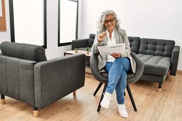 Obraz premium Middle age grey-haired businesswoman smiling happy working at the office.