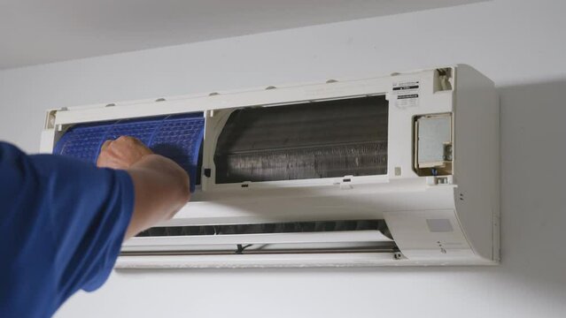 Technician placing back clean filter into air conditioner, man maintenance service installing air filter after washing cleaning, worker to service cleaning and repair, dust and dirt for healthy living