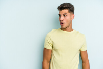 Obraz premium Young caucasian man isolated on blue background being shocked because of something she has seen.