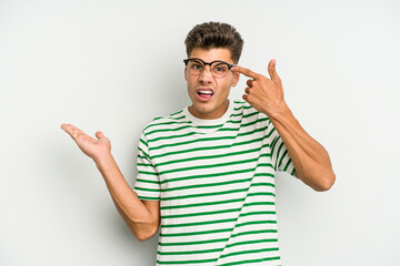 Fototapeta premium Young caucasian man isolated on white background holding and showing a product on hand.