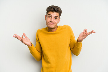 Young caucasian man isolated on white background doubting and shrugging shoulders in questioning gesture.