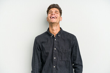 Obraz premium Young caucasian man isolated on white background relaxed and happy laughing, neck stretched showing teeth.
