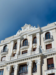 Fototapeta na wymiar Beige classical facade of building in central district downtown Madrid, Spain. Vertical photo
