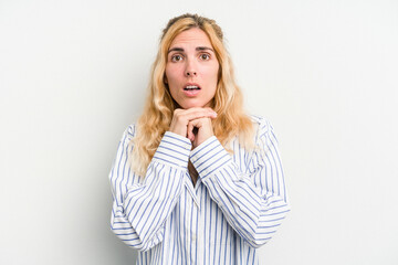 Young caucasian woman isolated on white background praying for luck, amazed and opening mouth looking to front.