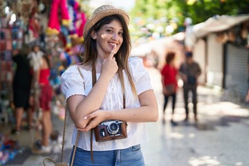 Young brunette woman on summer vacation smiling looking confident at the camera with crossed arms and hand on chin. thinking positive.