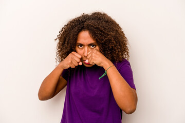 Young African American woman isolated on white background throwing a punch, anger, fighting due to an argument, boxing.