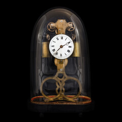 Ancient table clock inside a bell jar isolated on a black background