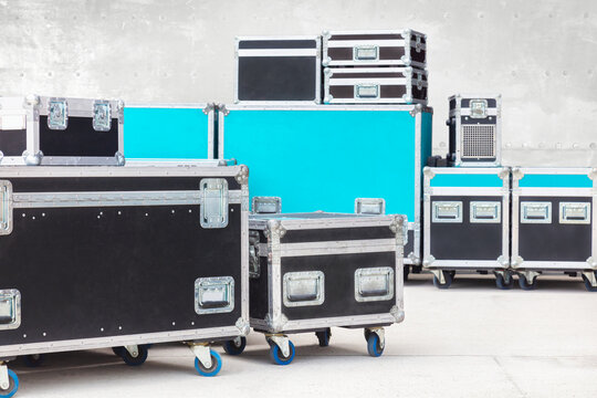 Group of black and blue flight cases on a concrete floor