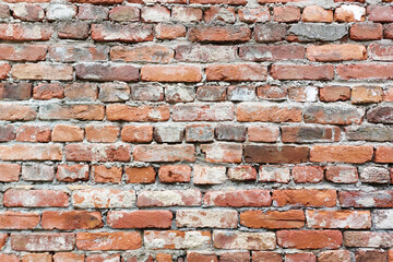Red old brick wall. Shabby and peeling.