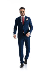 sexy confident businessman in suit with sunglasses walking