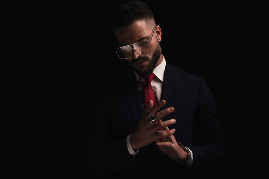 attractive bearded man with glasses looking down and touching palms