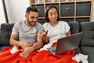 Young latin ill couple having medical teleconsultation using laptop at home.