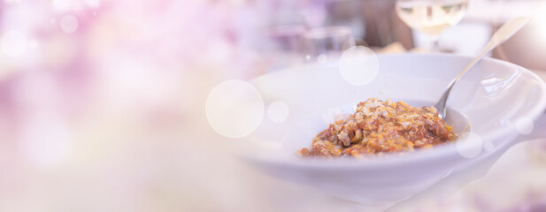 Pasta italien appetizer with restaurant view in a garden with bright bokeh. Horizontal tender pink...