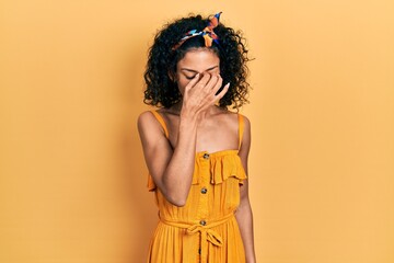 Young latin girl wearing summer dress tired rubbing nose and eyes feeling fatigue and headache. stress and frustration concept.