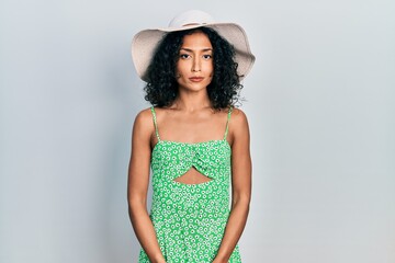 Young latin girl wearing summer hat depressed and worry for distress, crying angry and afraid. sad expression.