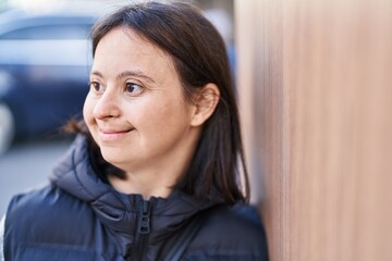 Young woman with down syndrome smiling confident looking to the side at street