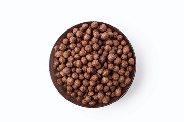 Chocolate corn flakes in a bowl on a white isolated background in the center of the image. Flakes...