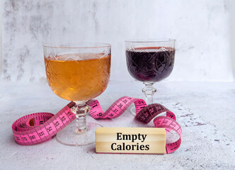 Glasses of wine and rose with  measuring tape and empty calories  text on wooden cubes 