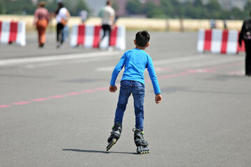A young boys first steps on inline skates.
